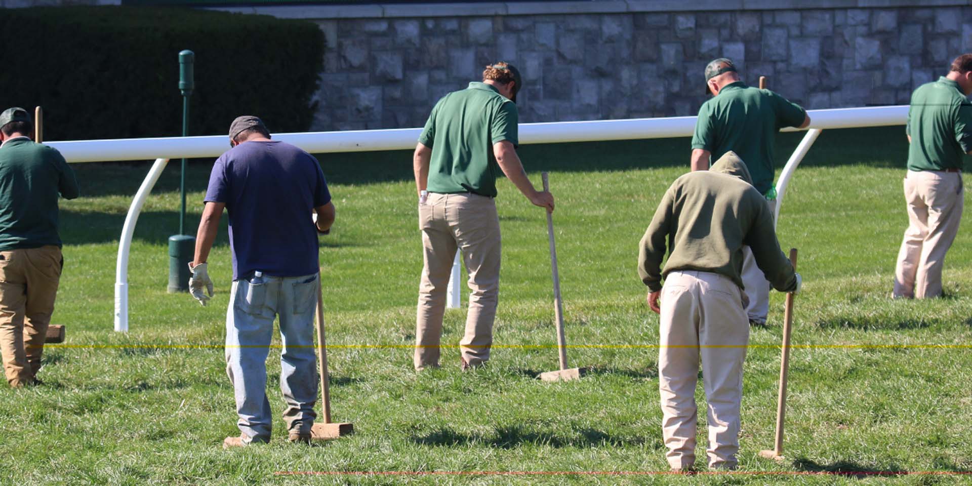 An action shot of Joggingstallion team members tamping down turf divots.